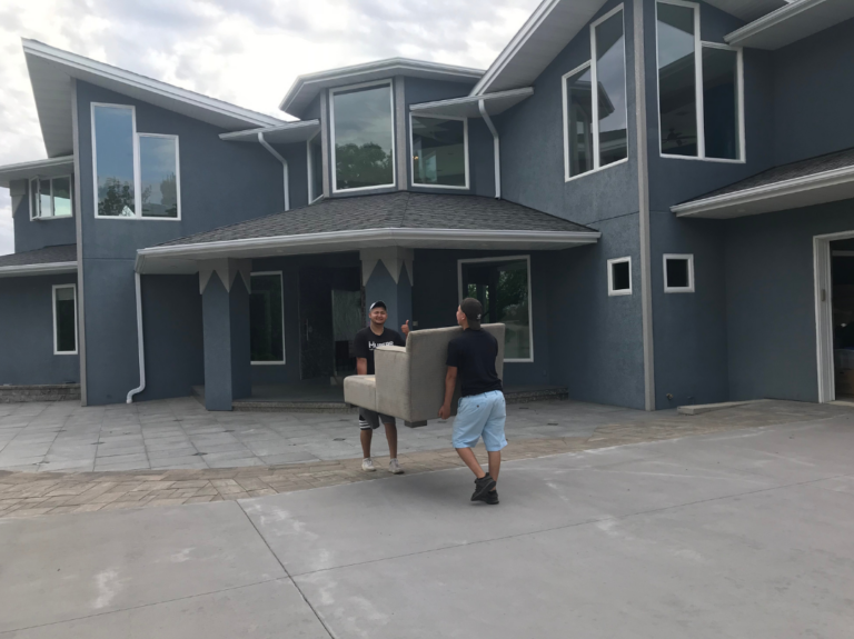 Movers moving couch into house