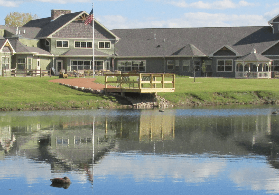Exterior of Willow Lane Assisted Living in Appleton, WI – pondfront facility with covered entrance and landscaped grounds